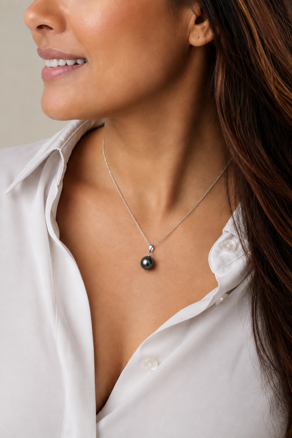 Model wearing Tahitian South Sea Pearl Sydney Pendant featuring a black round cultured pearl suspended from a delicate sterling silver chain.